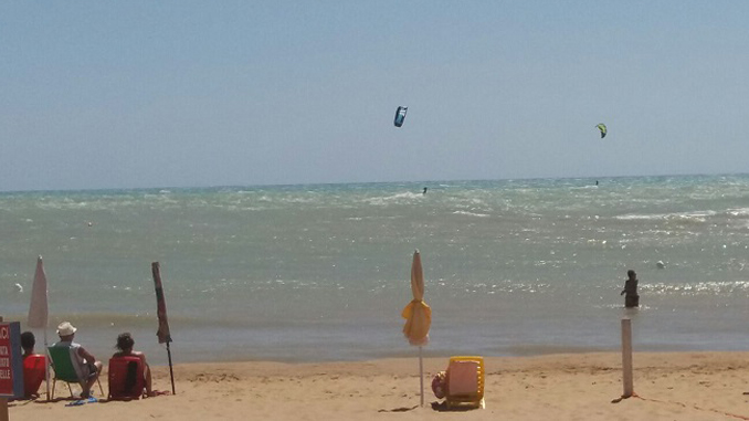 I kiters visti dalla spiaggia di Mollarella