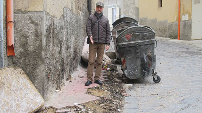 Padre Scordino mostra il marciapiede danneggiato